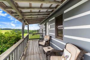 a porch with chairs and awning on a house at Private Mountain Nook with Jacuzzi - Cabin 6 in Fancy Gap