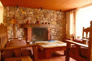 a stone room with a table and a stone wall at Huaira Huasi in Purmamarca