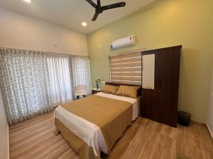 a bedroom with a bed and a ceiling fan at River Breeze Cherai in Cochin
