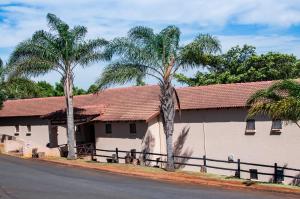 a building with two palm trees next to a street at Ocean View Villas B09 in Port Edward