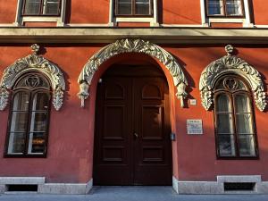 a red building with a brown door and two windows at B40 Green ApartRooms in Budapest