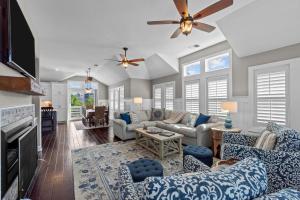 a living room with blue and white furniture and a ceiling fan at 4919 - The Leonardo in Kitty Hawk