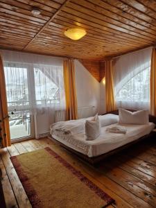 a bedroom with a large bed with a wooden ceiling at Casa Nobilă in Bran