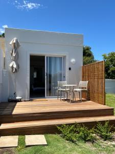 a wooden deck with a table and chairs on it at Mountain View Studio Hermanus in Hermanus