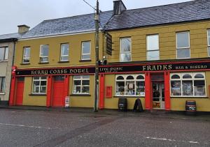 a row of buildings with red doors on a street at Kerry Coast Hotel in Cahersiveen
