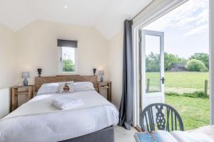 a bedroom with a bed and a large window at The Burrow in Biddenden