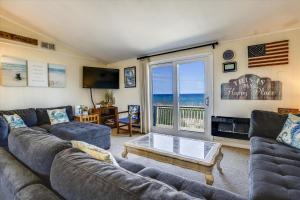 a living room with couches and a view of the ocean at 5010 - Once Upon A Tide in Kill Devil Hills