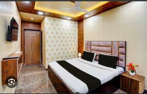 a bedroom with a large bed and a television at Hidden key guest house in Bhubaneshwar