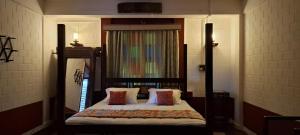 a bedroom with a bed with a wooden frame at Srikadhama in Udupi