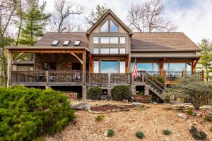 a house with a wrap around porch with a flag at Shady Maples Lodge in Townsend