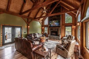 a living room with leather furniture and a fireplace at Shady Maples Lodge in Townsend