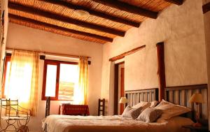 a bedroom with a large bed with a wooden ceiling at Huaira Huasi in Purmamarca