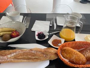a table topped with a plate of bread and orange juice at Villa Portal in La Grande Motte
