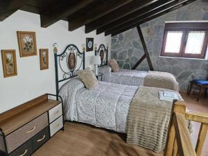 a bedroom with two beds and a dresser at Casa Las Hortensias Hoznayo in Entrambasaguas