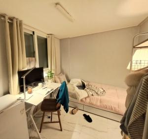 a bedroom with a bed and a desk with a computer at Dodahm guesthouse stay in Incheon
