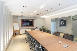 ein Konferenzraum mit einem großen Holztisch und Stühlen in der Unterkunft The Hub Urban Hotel in Asunción + 27 Fotos