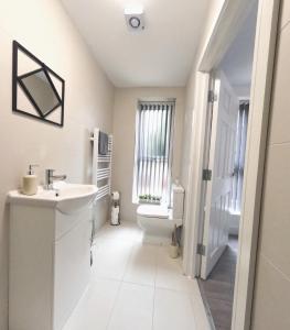 a white bathroom with a sink and a toilet at C- Spacious En-Suite Room Sheffield Centre in Victoria