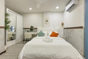 a bedroom with a large white bed and a desk at Cozy 1BHK Apartment in Central Malé in Male City