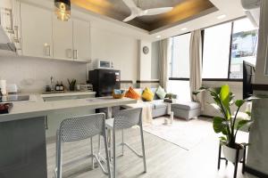 a kitchen and living room with chairs and a couch at Cozy 1BHK Apartment in Central Malé in Male City +35 photos