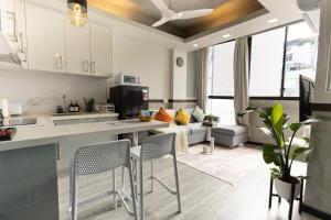 a kitchen and living room with a couch and chairs at Cozy 1BHK Apartment in Central Malé in Male City