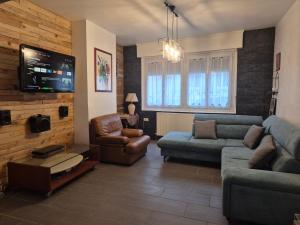 a living room with a couch and a tv at Maison Rosendalienne in Dunkerque