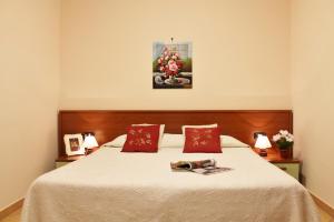アルビソーラ・スペリオーレにあるHouse Carla by Holiday Worldのベッドルーム1室(大型ベッド1台、赤い枕付)
