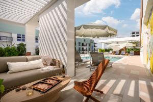 a living room with a couch and an umbrella and a pool at Sense28 Edgewater, an AvantStay Hotel in Miami