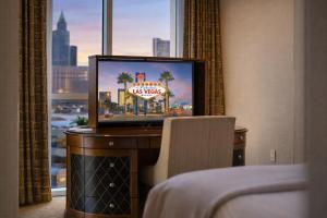 a television in a hotel room with a view of a city at MGM Signature Tower 2 8th Floor 2-Suite Strip View Balcony No Resort Fee in Las Vegas