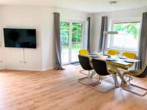 a dining room with a table and yellow chairs at Ferienhaus Emilius in Butjadingen
