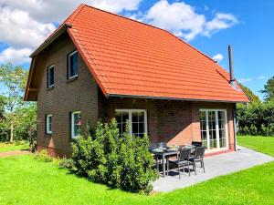 an orange roofed house with a table and chairs at Ferienhaus Emilius in Butjadingen