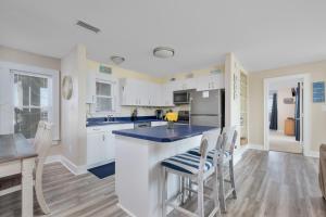 a kitchen with white cabinets and a blue counter top at 7662 - Sea La Vie in Avon +17 photos