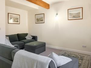 a living room with a couch and a chair at The Coach House in Kettlewell