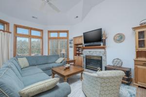 a living room with a blue couch and a fireplace at 4482 - Villa Al Mare in Duck