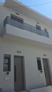a white building with a balcony and a door at 2BR Apartment for 5 in Archangelos Rhodes with Parking - Equus Sky in Archangelos