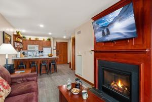 a living room with a fireplace with a tv above it at AS 326 No Resort Fee Pool-View Ski-InOut in Snowshoe