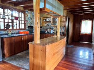 a kitchen with wooden cabinets and a wooden counter top at Hospedaje Cabañas Wohlrab in Oxapampa