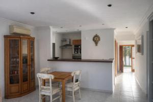 a kitchen with a wooden table and chairs at Vila Mimosa in Colonia de Sant Pere