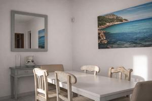 a dining room with a white table and chairs at Vila Mimosa in Colonia de Sant Pere