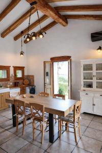a large kitchen with a wooden table and chairs at Spartaco Eco Retreat San Pantaleo in San Pantaleo