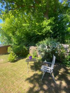 a table and a chair in a yard at Apartment am Waldrand Nichtraucher gemütlich und ruhig in Itzehoe