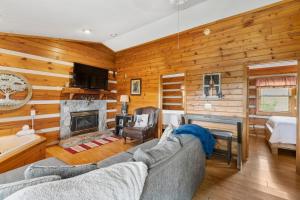 a living room with a couch and a fireplace at 2BR Cabin with Jacuzzi and Mountain Views - Cabin 5 in Fancy Gap