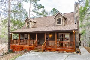 a house with a large deck in the woods at Nestled Inn in Townsend