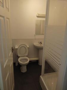 a small bathroom with a toilet and a sink at The Commodore Hotel in Nottingham