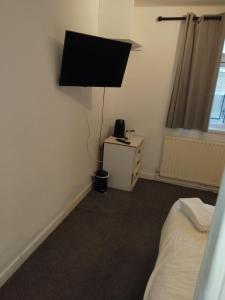 a bedroom with a bed and a lamp on the wall at The Commodore Hotel in Nottingham +8 photos