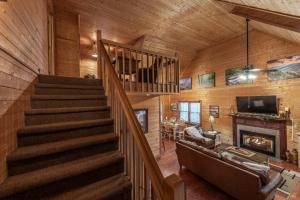 a staircase in a log cabin with a fireplace at Nestled Inn in Townsend