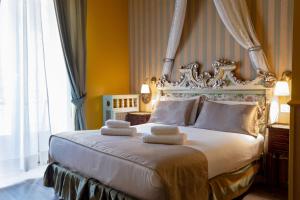 a bedroom with a large bed with towels on it at Casa della Contessa Art Guest House in Turin