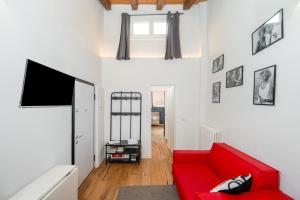 a living room with a red couch and a tv at Appartamento Elegante con 2 Camere nel Centro Storico di Bologna in Bologna