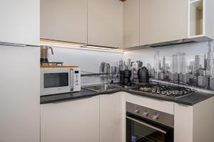 a kitchen with a microwave and a city skyline on the wall at Appartamento Elegante con 2 Camere nel Centro Storico di Bologna in Bologna