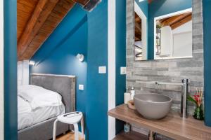 a bathroom with blue walls and a sink and a bed at Appartamento Elegante con 2 Camere nel Centro Storico di Bologna in Bologna +16 photos