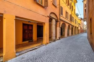 an empty street in an alley with yellow buildings at Appartamento Elegante con 2 Camere nel Centro Storico di Bologna in Bologna